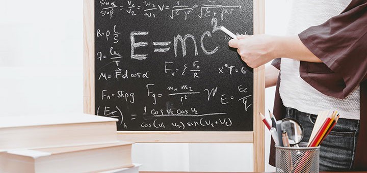En lärare och elev skriver matematik på en genomskinlig tavla