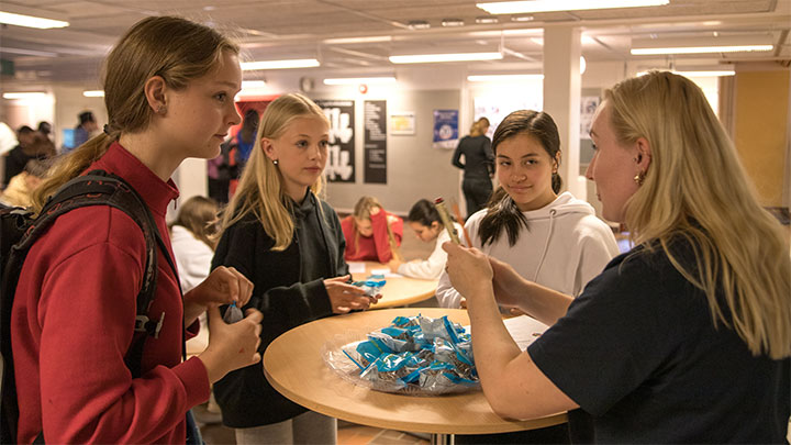 Tre elever får chokladboll av Petra Baastad från Örebro universitet.
