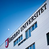 One of the buildings at Örebro University with the logo on the wall
