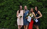 Fyra kvinnliga lärare tog examen, och poserar glatt tillsammans.