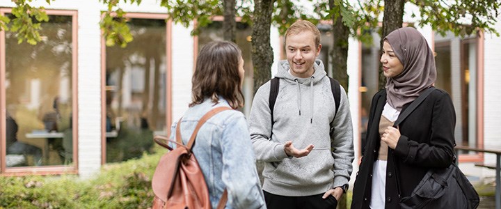 Tre studenter ute på campus.