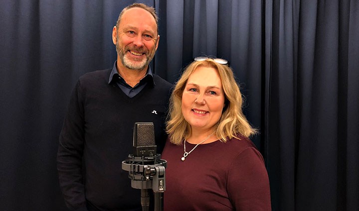 Helen Stockhult och Lars Johansson står bakom en mikrofon. 