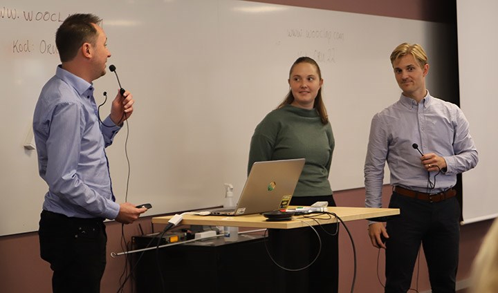 Joakim Norberg, Elin Rimhagen och Oscar Damberg presenterar sitt projekt framför en  whiteboard. 