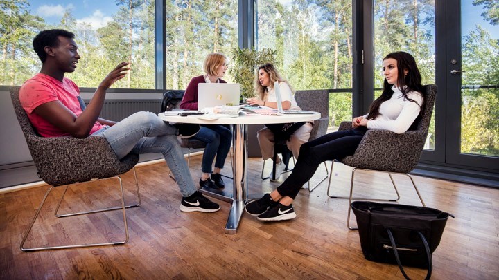 Studenter samtalar runt ett bord