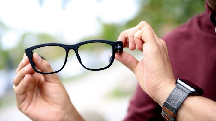 Person holding up a pair of glasses