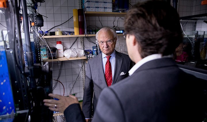 King Carl XVI Gustaf speaking with Steffen Keiter among the tanks with zebrafish.