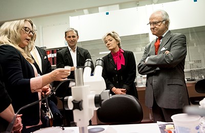 Vice-Chancellor Johan Schnürer, Professor Magnus Engwall, County Governor Maria Larsson and King Carl XVI Gustaf speaking with researchers Anna Kärrman and Anna Rotander.