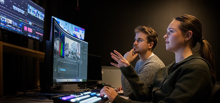 Två studenter redigerar film.