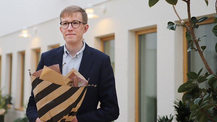 Einar Prytz står med blommor i handen. 