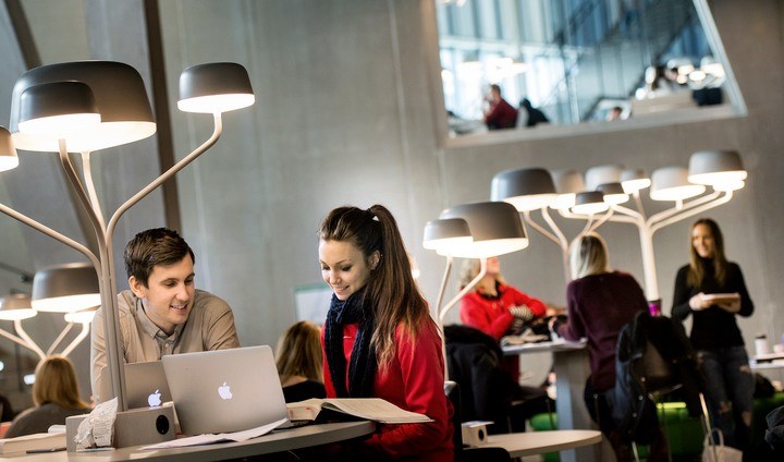 Två studenter tittar på en bärbar dator.