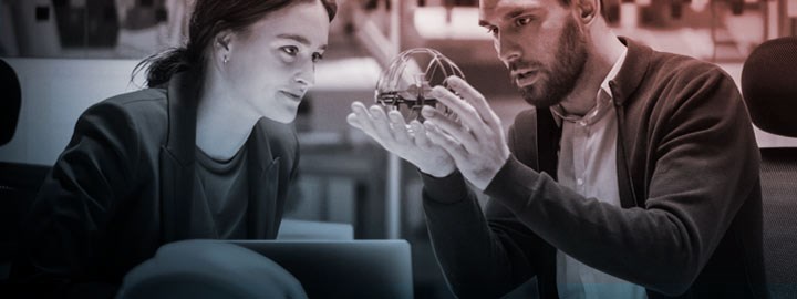 A woman and a man are studying a spherical object.