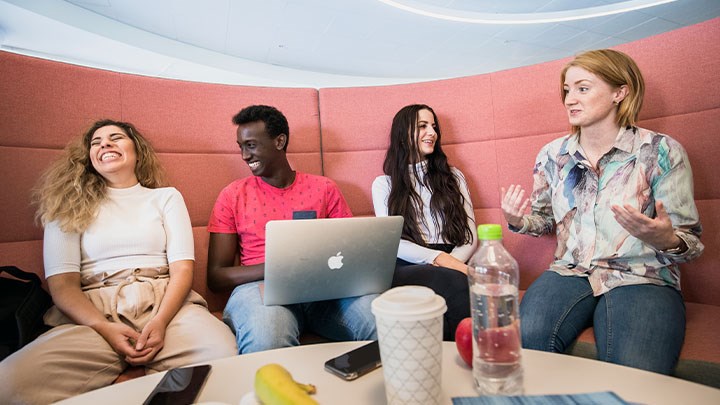 A photo of four people in a sofa.