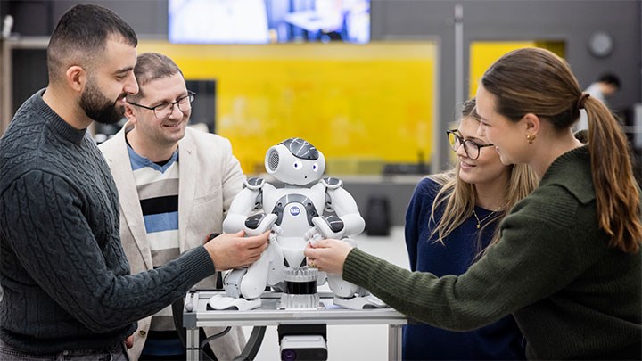 Några forskare undersöker en robot.