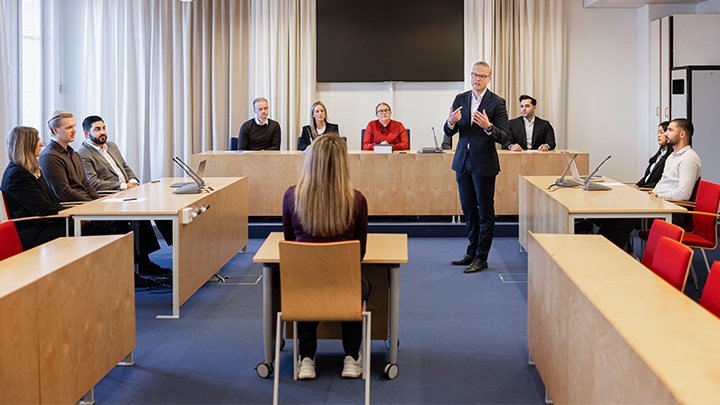 En grupp studenter övar under ett rättegångsspel i en träningsrättssal på Campus Örebro.