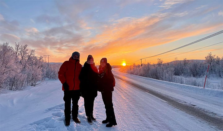 Three students in a beautiful winter landscape sunset.