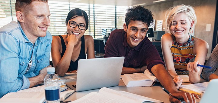 En grupp studenter framför två laptops.