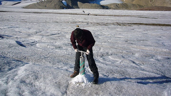 Person drilling in ice in Svalbard