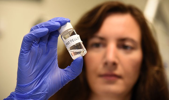 Christine Schönlau is holding a jar containing plastic microbeads.