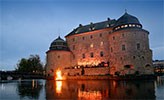 Örebro slott med valborgsbrasan i Svartån och kören framför slottet.