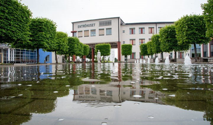 Entréhuset på Örebro universitet med vattenspegeln i Krakadammen i förgrunden.