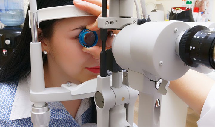 Kvinna undersöker synen hos optiker.