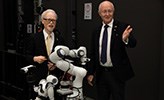 Japans ambassadör och Örebro universitets rektor bakom en robot.