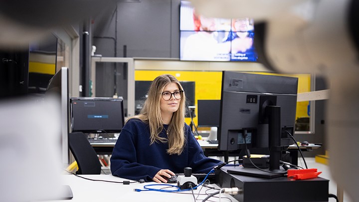 En student sitter vid en dator i robotsalen.