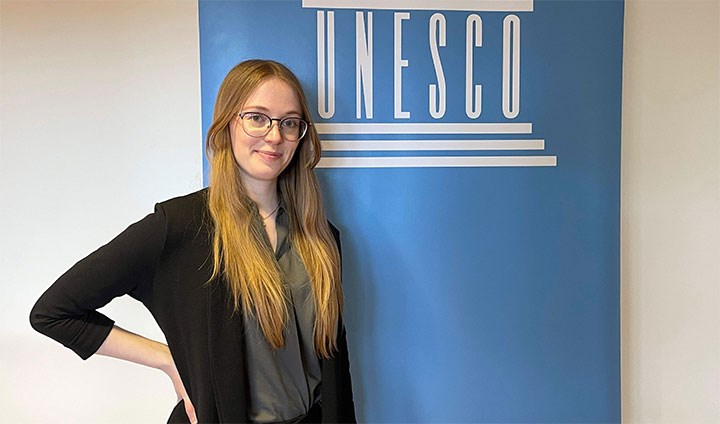 Josefine Persson står framför Unescos logotyp.