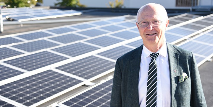 Rektor Johan Schnürer står framför solpaneler på taket på Långhuset.
