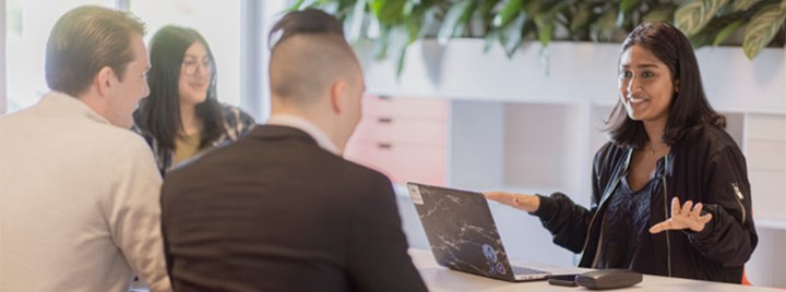 Studenter sitter runt ett bord och löser en uppgift.