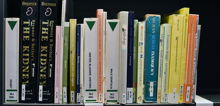 Foto på bokryggar av böcker som står i en bokhylla
