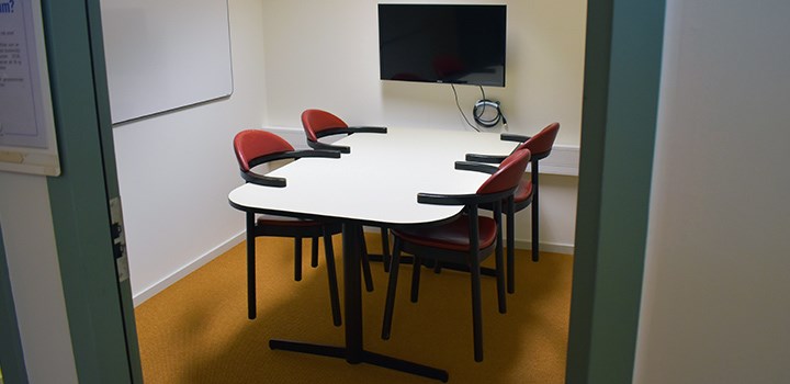 Foto av grupprum med bord och fyra stolar