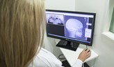 Foto på en person som tittar på en datorskärm som visar röntgenbilder.