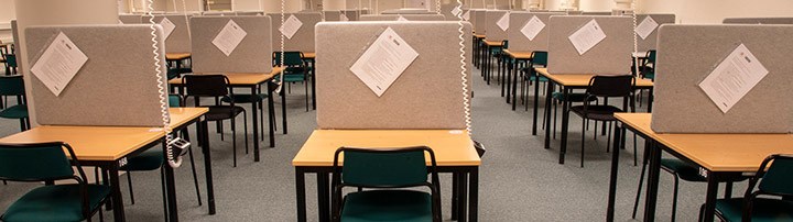 Examination hall with desks lined up in a row.