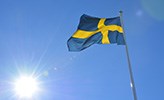 En svensk flagga mot blå himmel.