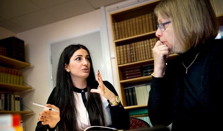 Två personer i ett kontorsrum diskuterar med varandra