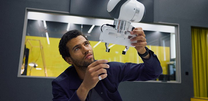 En man inspekterar en robot på Robotlabbet.