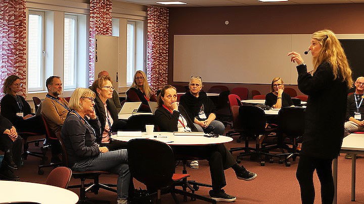 En person står inför en grupp personer.
