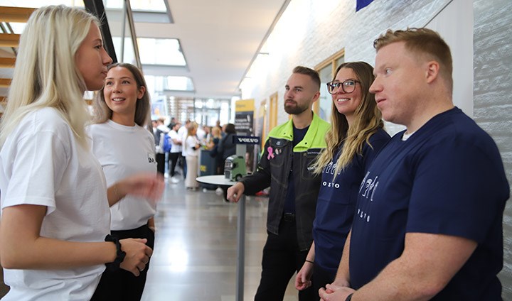 Två studenter pratar med tre medarbetare från Volvo.