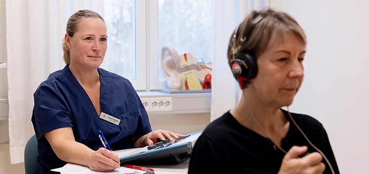 En sjuksköterska testar hörseln på en patient.