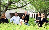 Sju studenter står bland grönska på Örebro universitets campus.