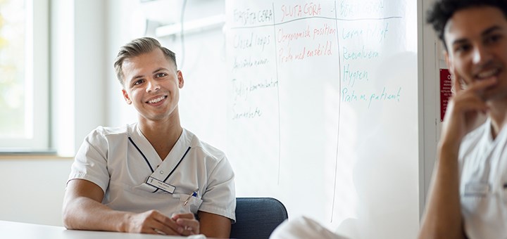 Två läkarstudenter sitter vid ett bord på Campus USÖ.