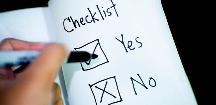 Hand ticking YES on a checklist.