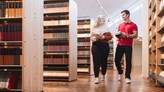 Två personer håller i böcker och går i huvudbiblioteket.
