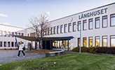 A person walking outside Långhuset at Örebro University.