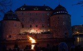 Örebro slott med en brasa framför.