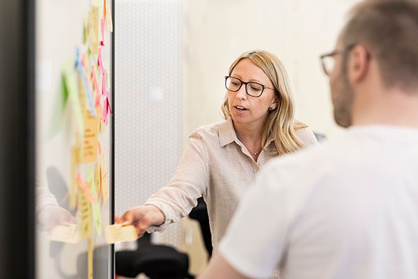 Två personer framför en whiteboard.