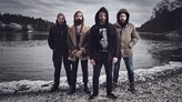 Metal-bandet Horndals fyra medlemmar står framför en sjö. 