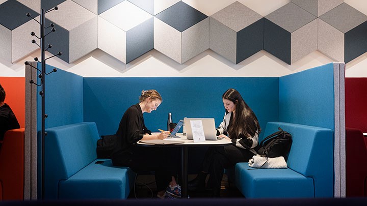 Två studenter sitter och pluggar.