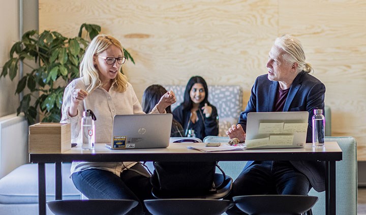 A woman and a man are sitting at a table and talking.